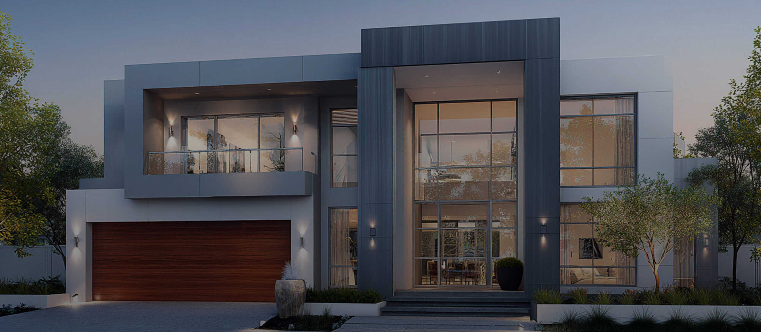 Modern two-story house with large windows, a balcony, gray exterior panels, wooden garage door, and landscaped front yard at dusk.